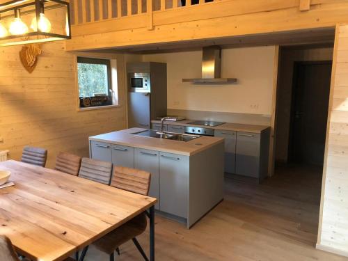 Il comprend une cuisine avec une table en bois et du parquet. dans l'établissement Chalet Tjaffers lodge, à Durbuy