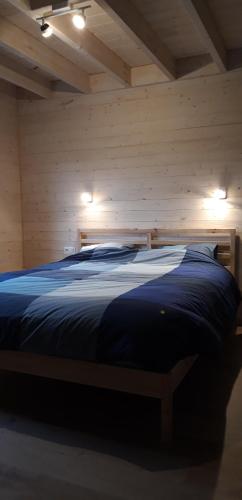 a bedroom with a bed in a wooden room at Chalet Tjaffers lodge in Durbuy