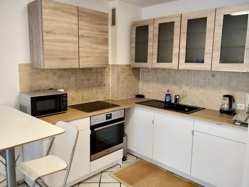 uma cozinha com armários brancos, um lavatório e um micro-ondas em AVI Deluxe Altstadt Apart em Dusseldorf