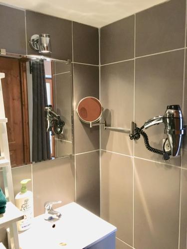a bathroom with a shower with a mirror and a sink at JunoGîte - Résidence in Bernières-sur-Mer