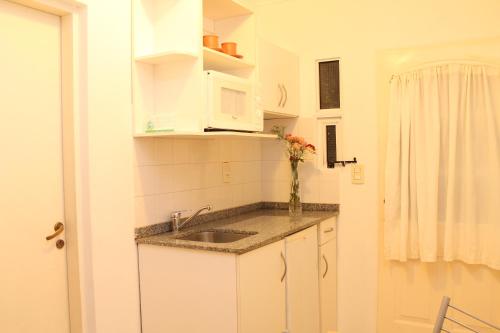 a kitchen with a sink and a vase of flowers at Brisas del Lago Apart y Hotel in Federación
