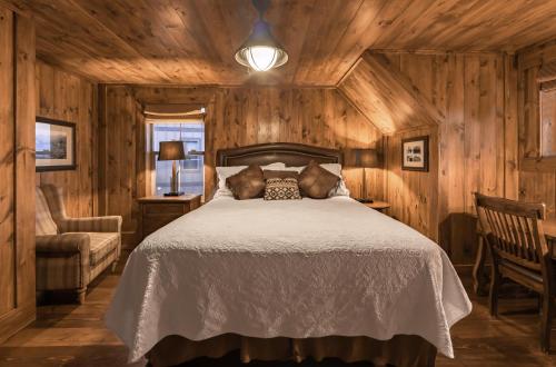 a bedroom with a bed and a chair and a lamp at Holiday Inn Club Vacations - David Walley's Resort in Genoa