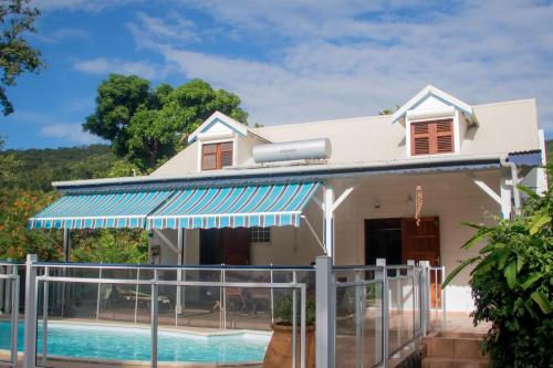 a house with a swimming pool in front of it at Villa Les Gallières in Pointe-Noire
