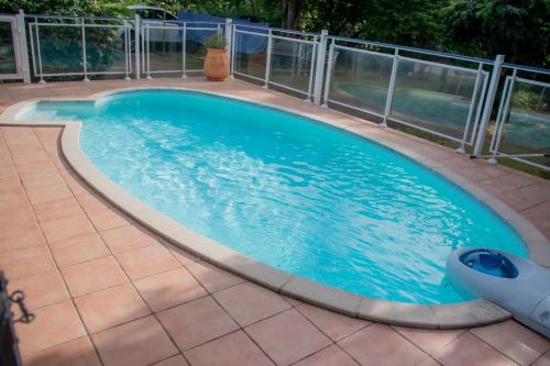 a swimming pool with a metal fence around it at Villa Les Gallières in Pointe-Noire