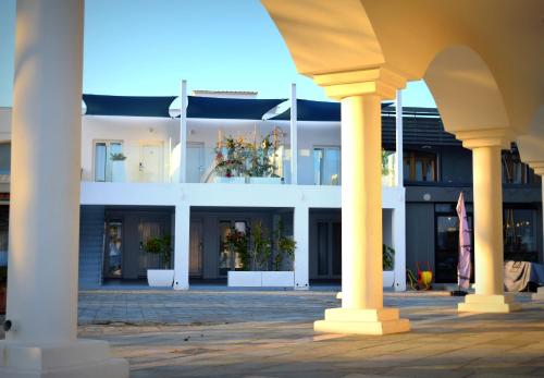 ein Gebäude mit Säulen und Blumen im Innenhof in der Unterkunft Ocean Dreams Suites in Ayia Napa