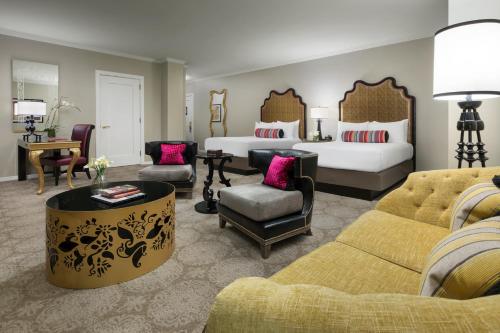 a hotel room with two beds and a living room at Huntington Hotel in San Francisco