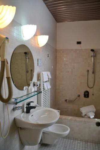 a bathroom with a sink and a toilet and a mirror at Hotel Italia in Foligno