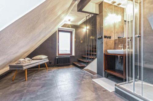 a attic bathroom with a sink and a staircase at Apartment Charlie in Prague
