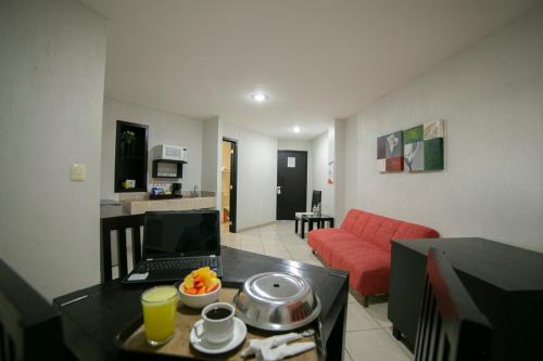 a living room with a couch and a table with a laptop at Hotel RS Suites in Tuxtla Gutiérrez