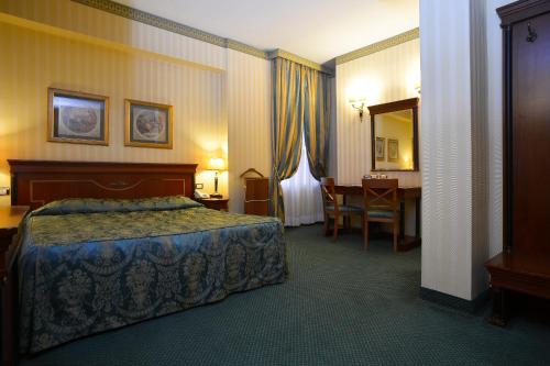 una camera d'albergo con letto e scrivania di Zanhotel Europa a Bologna