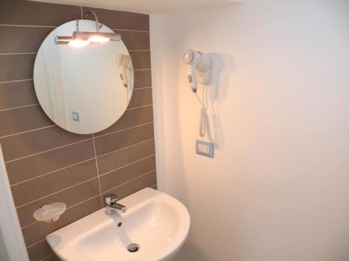 uma casa de banho com um lavatório e um telefone na parede em Bibione Mastervillage em Bibione