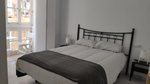 カディスにあるApartamento El Gaditano Erranteのベッドルーム1室(大型ベッド1台、黒いヘッドボード付)