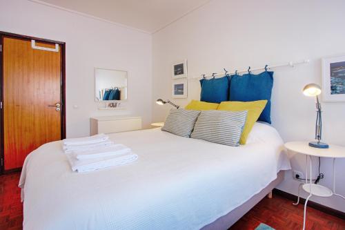 アヴェイロにあるSailing Apartment Aveiroのベッドルーム(白いベッド、青と黄色の枕付)