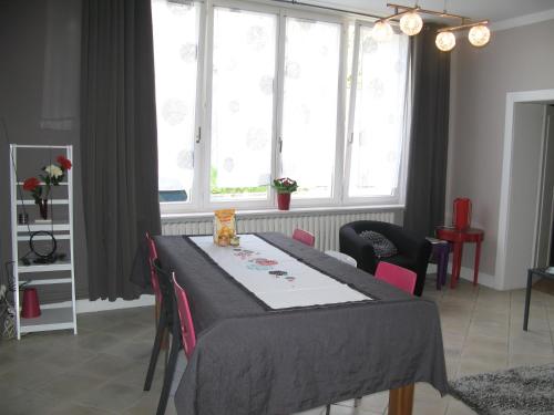 a dining room with a table and chairs and windows at Les Jardins du Golf in Metz