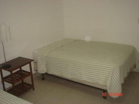 a bedroom with a bed and a wooden table at Dre Broeders Apartments Juan Dolio in Juan Dolio