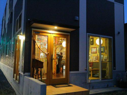 a person standing in the doorway of a store at night at ホステル富士山 結 in Fujiyoshida