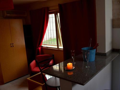 una cocina con una mesa con una vela y una ventana en Vía Lavalle Suites en San Luis