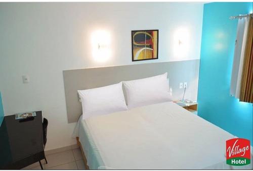 Village Hotel Belém : غرفة نوم مع سرير أبيض كبير في غرفة