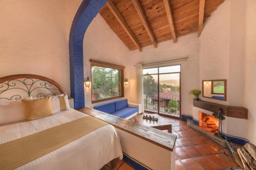 a bedroom with a large bed and a fireplace at Tapalpa Country Club Hotel in Tapalpa