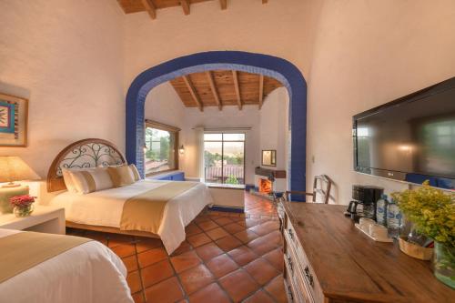 a bedroom with a bed and a tv in a room at Tapalpa Country Club Hotel in Tapalpa