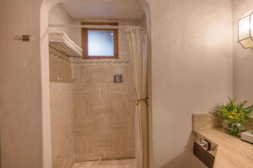 a bathroom with a shower with a glass door at Tapalpa Country Club Hotel in Tapalpa