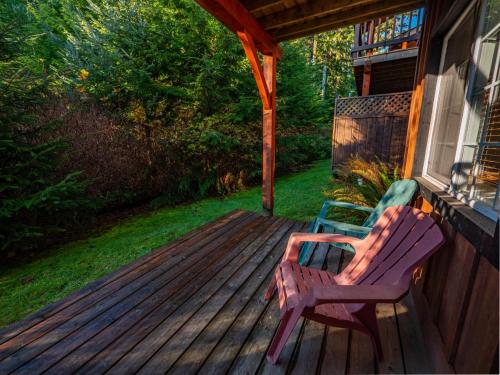 a porch with two chairs sitting on a deck at The Cabins at Terrace Beach in Ucluelet