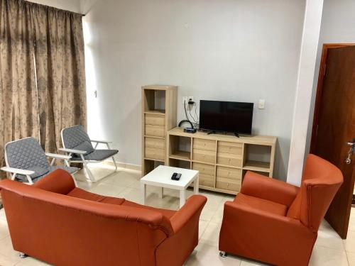 a living room with two chairs and a television at WilMar Apart Hotel in Encarnación