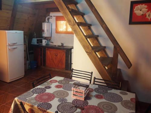a kitchen with a table and a refrigerator at Cabañas los 4 elementos in Santa Rosa de Calamuchita