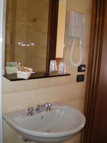 a bathroom with a sink and a phone on the wall at Hotel Giulia in Marina di Massa