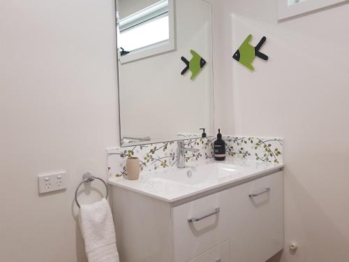 a white bathroom with a sink and a mirror at Fish Creek Adrift Accommodation in Fish Creek