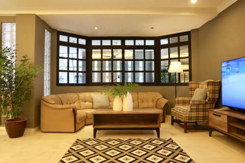 uma sala de estar com um sofá e uma televisão em G Beach Front Villa em Batu Ferringhi