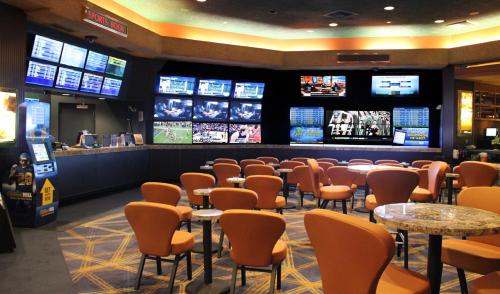 a sports bar with tables and chairs and televisions at Cactus Petes Resort & Horseshu Hotel in Jackpot