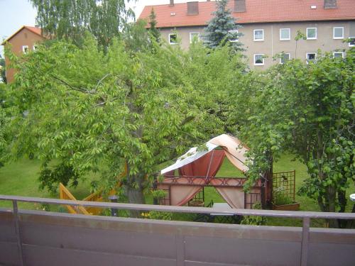 a gazebo in a tree next to a building at ApartmentHotel Vollumen in Redwitz an der Rodach