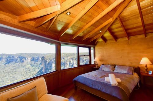 a bedroom with a bed and a large window at Amaroo Mountaintop Villa in Katoomba