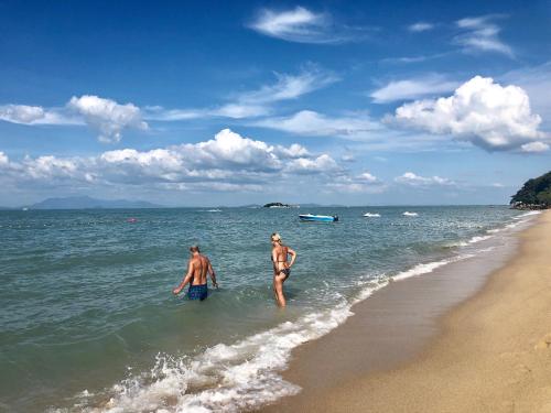 two people standing in the water at the beach at G Beach Front Villa in Batu Ferringhi