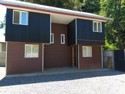 una casa marrón con techo negro en Los Arrayanes de Harnecker, en Valdivia
