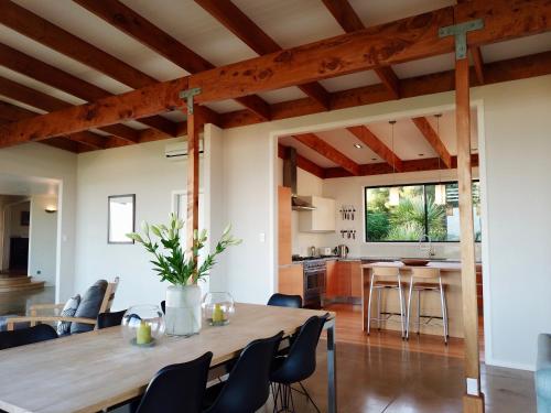 a dining room and kitchen with a wooden table and chairs at Te Kahu Pacific View in Whangarei