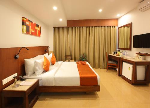 um quarto de hotel com uma cama, uma secretária e um computador em Park Residency em Cochin