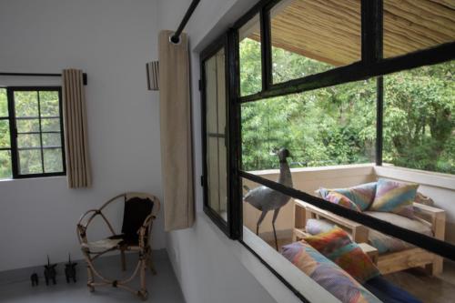 a living room with a couch and a window at Arusha Villa Karamu Coffee Estate in Usa River