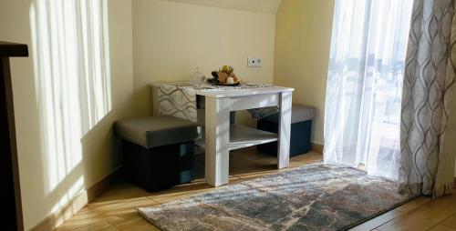 a small white table with a chair and a stool at Apartamenty u Klisia in Ząb