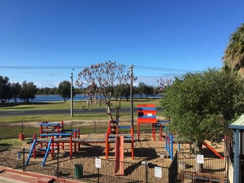 a playground with colorful equipment in a park at Villa by the Lake in Lakes Entrance