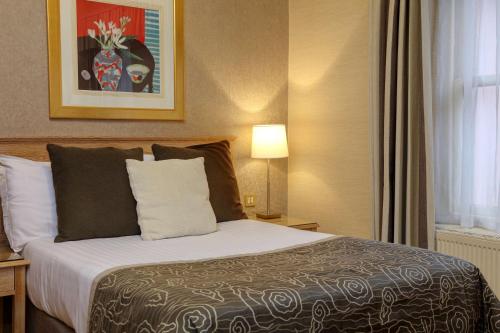 a bedroom with a bed in a room with a window at Norfolk Royale Hotel in Bournemouth