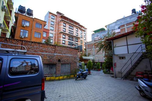 a van parked on a city street with buildings at Apsara Boutique Hotel in Kathmandu
