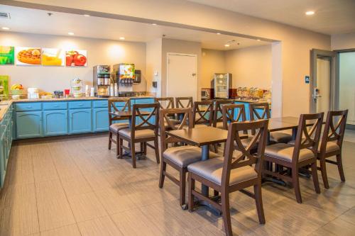 a restaurant with wooden tables and chairs and a counter at Quality Inn Merced Gateway to Yosemite in Merced