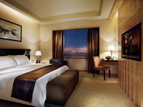 Habitación de hotel con cama y ventana en Resorts World Genting - Genting Grand en Genting Highlands
