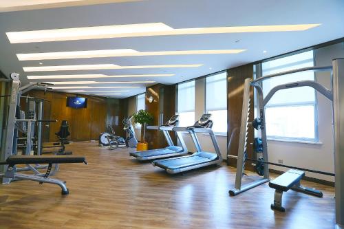 a gym with several treadmills and elliptical machines at Yinchuan Xifujing Hotel in Yinchuan