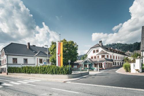a street in a town with white houses at Das Salvator Iris Porsche Landhotel in Friesach