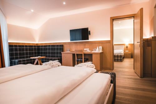 a hotel room with two beds and a flat screen tv at Das Salvator Iris Porsche Landhotel in Friesach