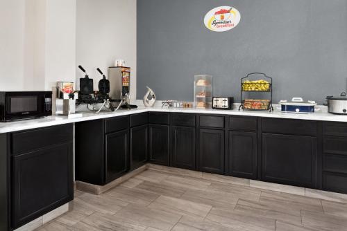 una cucina con armadi neri e ripiani bianchi di Super 8 by Wyndham Des Moines a Des Moines