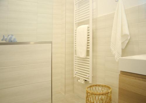 ein Badezimmer mit einer Dusche mit einem Heizkörper und einem Waschbecken in der Unterkunft Ferienwohnung KNUT am Hafen in Heiligenhafen